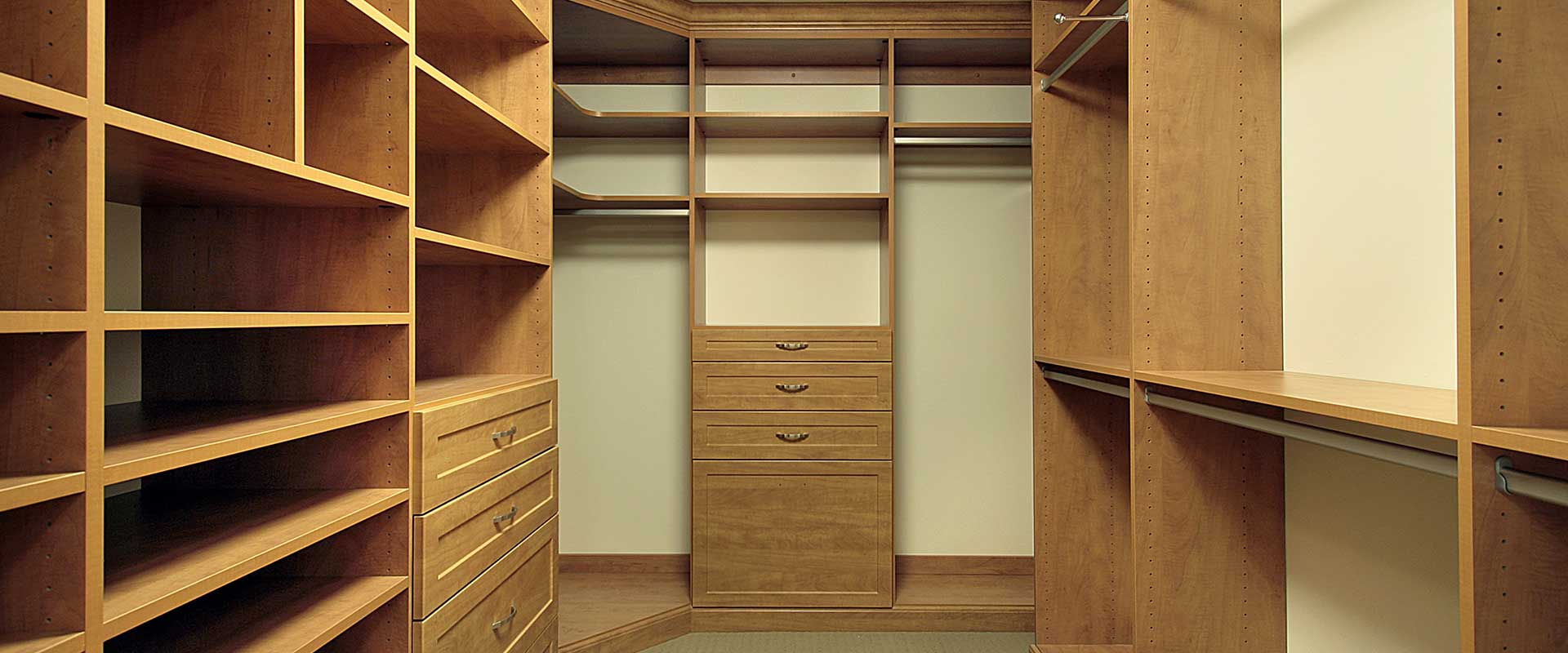Custom walk-in closet design with built-in shelves, hanging rods, and organized storage by Neatly Closets
